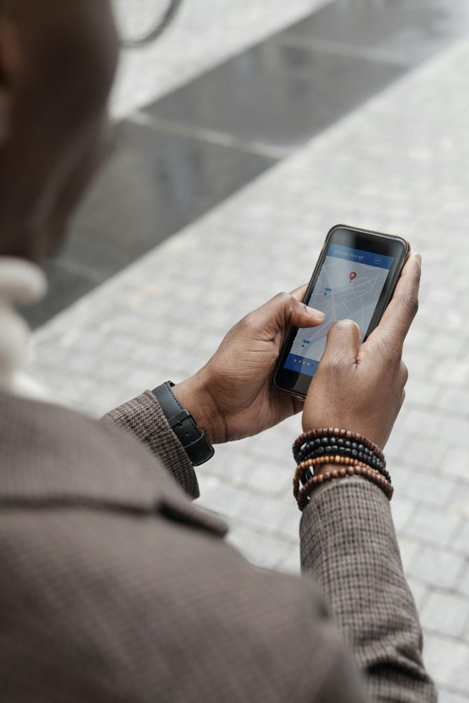A man checking GPS navigation on a smartphone in a city street.