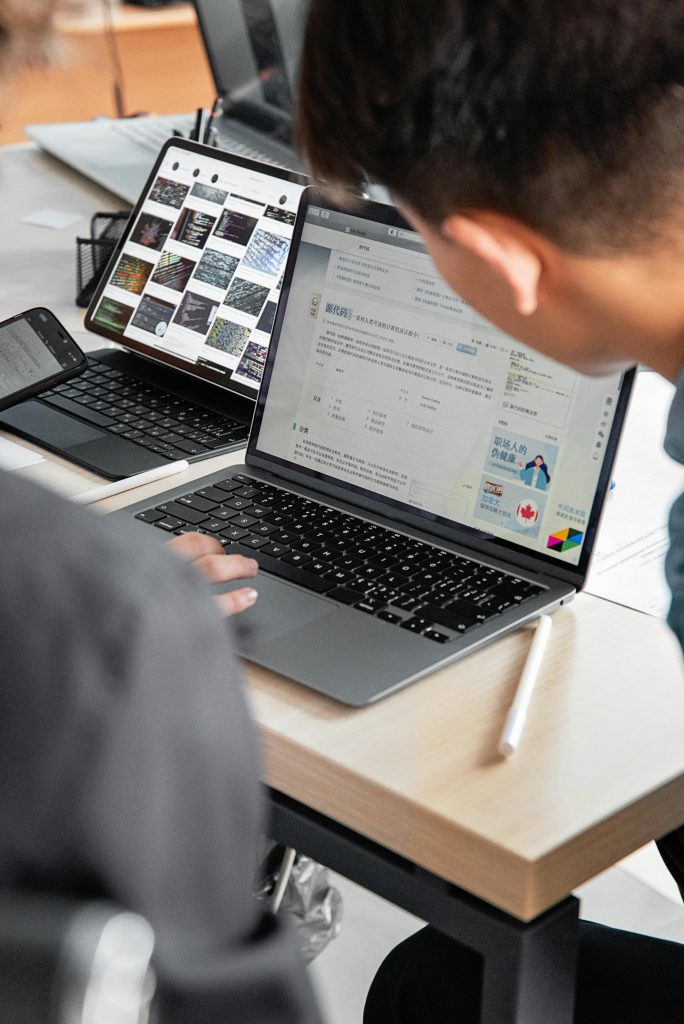 A modern office workspace with laptops and tablets showcasing collaborative tech use.